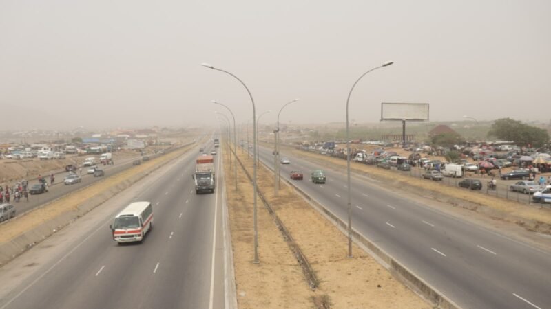 A divided Nigerian highway with light traffic, seen from an overpass, photographed in Abuja
