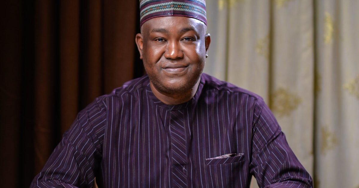 Gbenga Olawepo-Hashim seated with his hands resting on a table