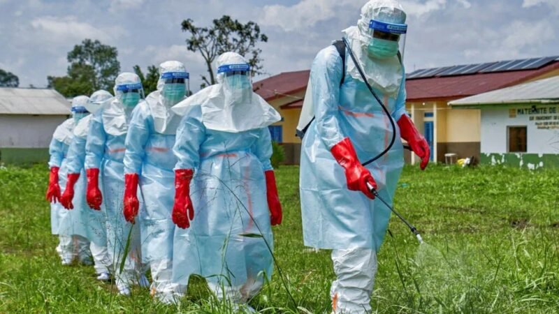 Health workers in full protective kit spraying a compound during an Ebola response drill. Contextual photograph.