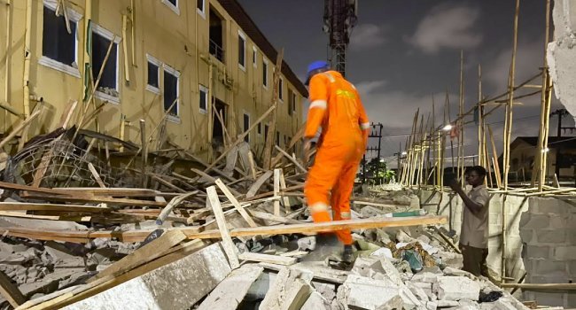 An emergency responder stands amid rubble after a building collapse in Fadeyi, Lagos.