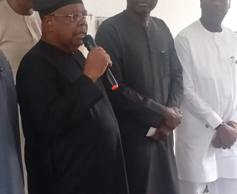 An official speaks into a handheld microphone beside other officials at the Lagos electricity-market retreat