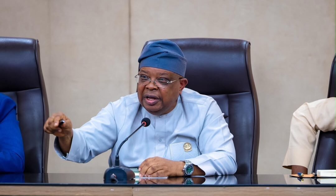 Joseph Tegbe speaking into a microphone at a meeting