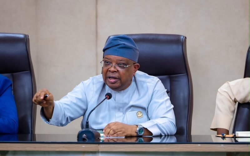 Joseph Tegbe speaking into a microphone at a meeting