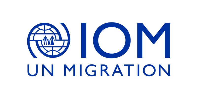 The logo of the International Organization for Migration reading IOM, UN MIGRATION.