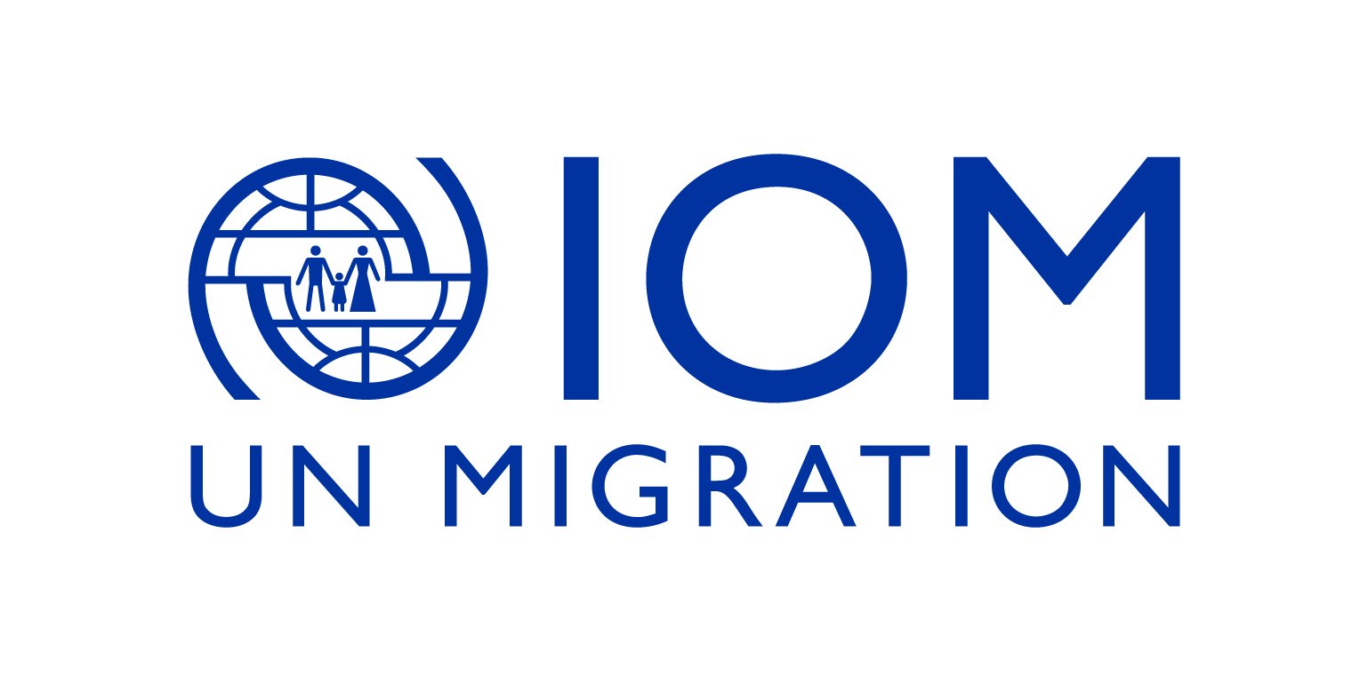 The logo of the International Organization for Migration reading IOM, UN MIGRATION.