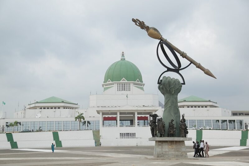 The National Assembly complex in Abuja seen across the forecourt, with the mace monument in the foreground.