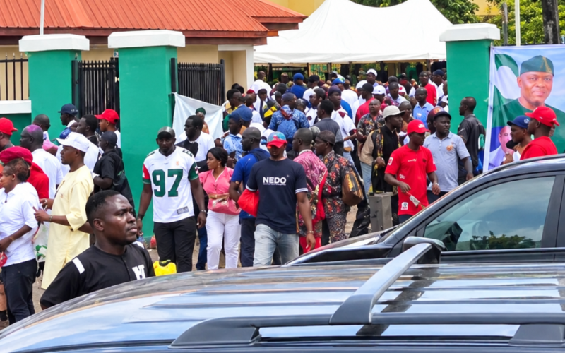 NDC supporters gathered near parked vehicles in Enugu