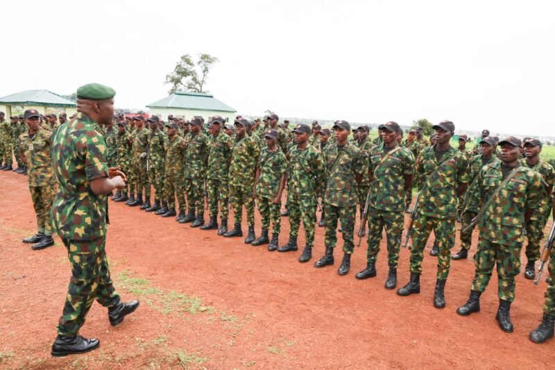 A Nigerian Army officer addresses a formation of soldiers drawn up on a parade ground.